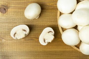 Raw fresh mushroom champignons on wooden table, top view.