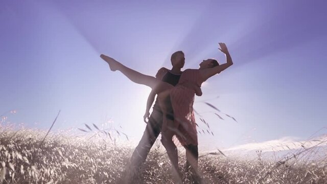 Aerial: Male and female ballet dancer embracing with light rays coming through them
