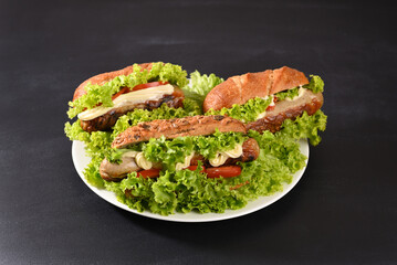 Hot dog with lots green salad and fried sausages
