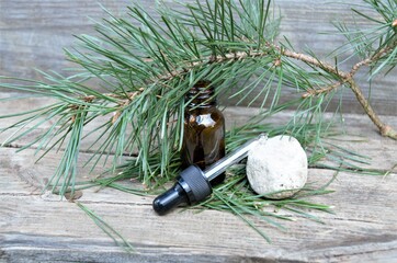 Cosmetic bottle brown on natural stone with pine branches on a wooden background. concept of...