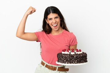 Young caucasian woman holding birthday cake isolated on white background celebrating a victory