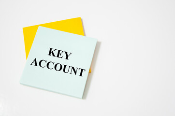 key account text written on a white notepad with colored pencils and a yellow background. word