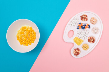 Global Pharmaceutical Industry and Medicinal Products - Different Colored Pills, Tablets and Capsules on White Art Palette with Yellow Vitamins Lying on Split Blue and Pink Background, Flat Lay