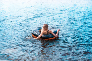 teen girl swimming using a swim tube