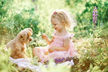 Little girl with a Yorkshire terrier puppy, outdoor summer