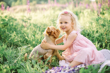 Little girl with a Yorkshire terrier puppy, outdoor summer