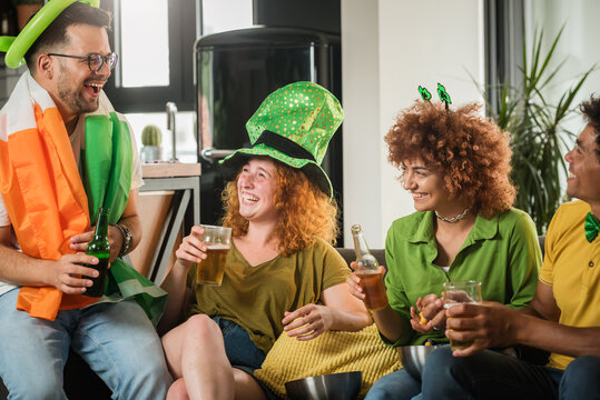 Multiethnic Group Of Young People Having Fun And Drinking Beer Together. Ireland national symbols. St Patricks Day.
