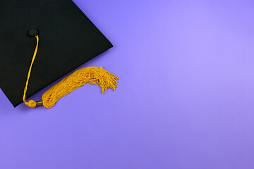 Back to school. Black graduation cap on a purple background. Graduation concept. Black Mortar Board...