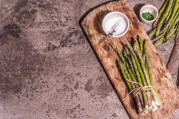 Bunch of fresh green asparagus on vintage wooden chopping board