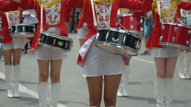 Street performance. Close-up of female drummers hands in red vintage uniform at the parade