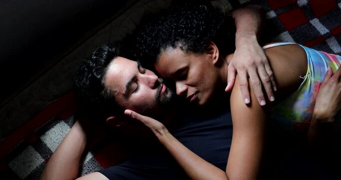 Brazilian couple lying in bed kissing. hispanic south american people romantic moment