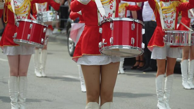 Young girls drummer in red vintage uniform at the parade. Street performance. Parade of majorettes