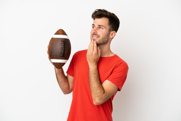 Young caucasian man playing rugby isolated on white background looking up while smiling