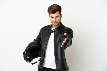 Young caucasian man with a motorcycle helmet isolated on white background shaking hands for closing a good deal