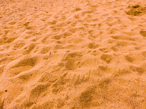 Bright photo of orange beach sand texture. 