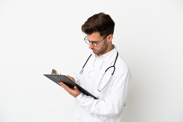 Young doctor caucasian man over isolated on white background wearing a doctor gown and holding a folder