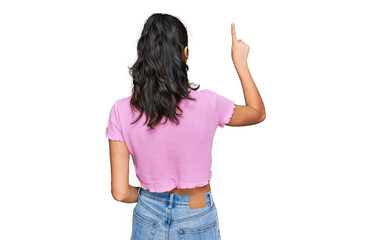 Hispanic teenager girl with dental braces wearing casual clothes posing backwards pointing ahead with finger hand