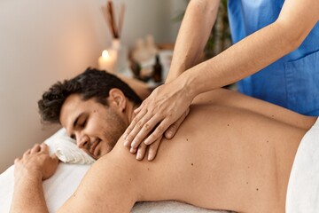 Man smiling happy reciving back massage at beauty center.