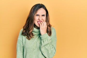 Young hispanic girl wearing casual clothes looking stressed and nervous with hands on mouth biting nails. anxiety problem.