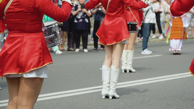Young girls drummer in red vintage uniform at the parade. Street performance. Parade of majorettes
