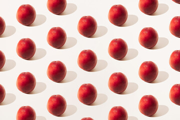 Arranged red peaches on a light background. Summer minimal pattern.