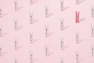 Pink and white wooden clip on a pink background. Minimal design and pattern.