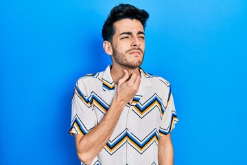 Young hispanic man wearing casual clothes touching painful neck, sore throat for flu, clod and infection