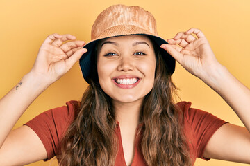 Young hispanic girl wearing casual clothes and hat smiling with a happy and cool smile on face. showing teeth.