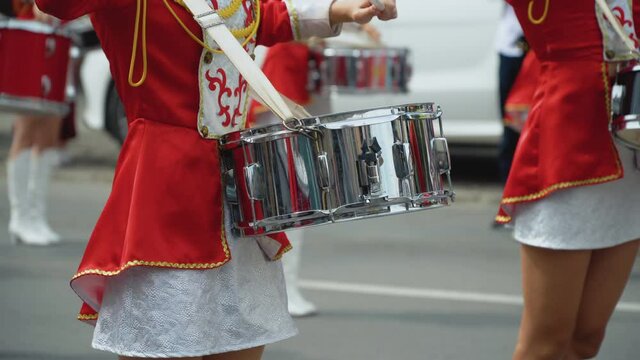 Close-up of female drummers hands in red vintage uniform at the parade. Parade of majorettes