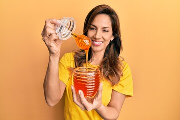 Young latin woman holding honey smiling with a happy and cool smile on face. showing teeth.