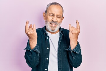Handsome senior man with beard doing rock gesture winking looking at the camera with sexy...