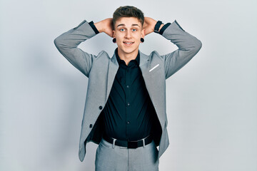 Young caucasian boy with ears dilation wearing business jacket relaxing and stretching, arms and hands behind head and neck smiling happy