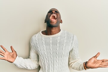 Young african american man wearing casual clothes celebrating mad and crazy for success with arms...