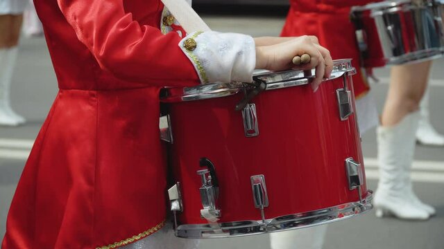 Close-up of female drummers hands in red vintage uniform at the parade. Parade of majorettes