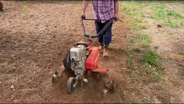 Hombre arando el campo con mula mec&aacute;nica