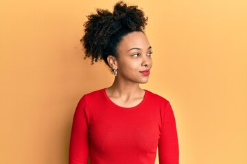 Young african american girl wearing casual clothes looking to side, relax profile pose with natural face and confident smile.