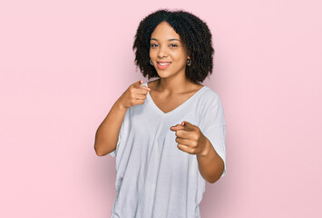 Young african american girl wearing casual clothes pointing fingers to camera with happy and funny face. good energy and vibes.