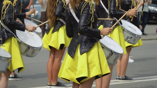 Young girls drummer in yellow black vintage uniform at parade. Street performance. Parade of majorettes