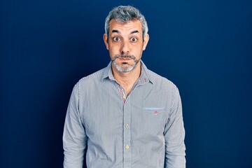 Obraz premium Handsome middle age man with grey hair wearing business shirt puffing cheeks with funny face. mouth inflated with air, crazy expression.