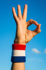 Close-up of hand of an athlete wearing red white and blue colors wristband making okay sign