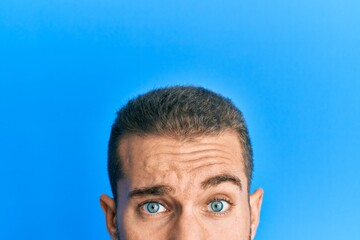 Young caucasian man showing head and half face clueless and confused expression. doubt concept.