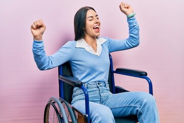 Beautiful woman with blue eyes sitting on wheelchair dancing happy and cheerful, smiling moving...