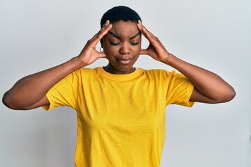 Young african american woman wearing casual yellow t shirt with hand on head, headache because stress. suffering migraine.