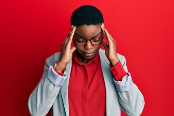 Obraz premium Young african american woman wearing business jacket and glasses with hand on head for pain in head because stress. suffering migraine.