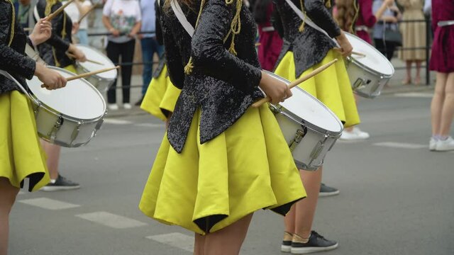Young girls drummer in yellow black vintage uniform at parade. Street performance. Parade of majorettes