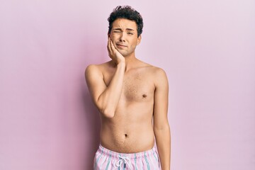 Fototapeta premium Young handsome man wearing swimwear shirtless touching mouth with hand with painful expression because of toothache or dental illness on teeth. dentist