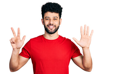 Young arab man with beard wearing casual red t shirt showing and pointing up with fingers number eight while smiling confident and happy.