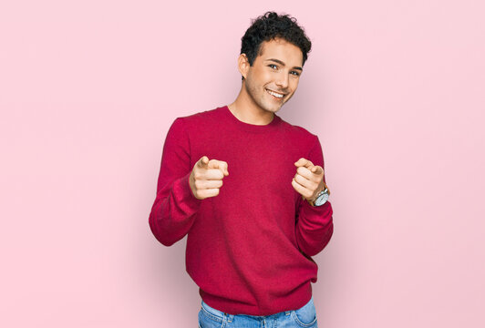 Young handsome man wearing casual clothes pointing fingers to camera with happy and funny face. good energy and vibes.
