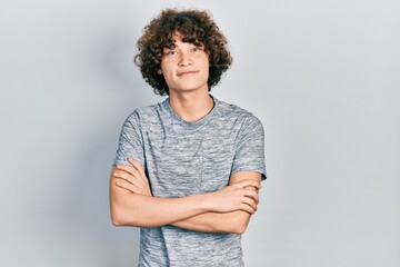 Handsome young man wearing casual grey t shirt happy face smiling with crossed arms looking at the camera. positive person.