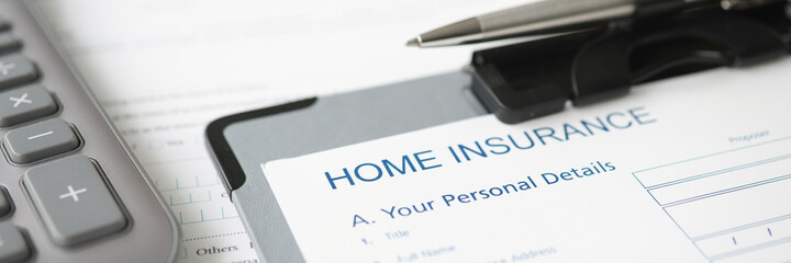 Home insurance documents and ballpoint pen lying on desktop closeup